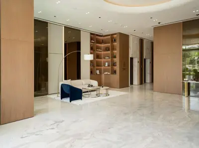 a lobby with a white couch and a table at Elegant Studio Stay in Binghatti Tulip Dubai in Dubai
