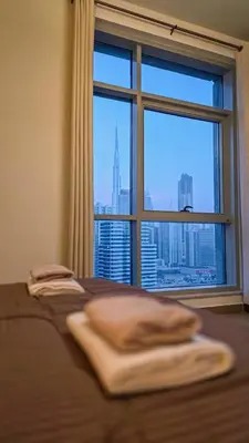 a bed with a window with a view of a city at Stylish Dubai Stay in Dubai