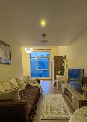 a living room with a couch and a television at Stylish Dubai Stay in Dubai