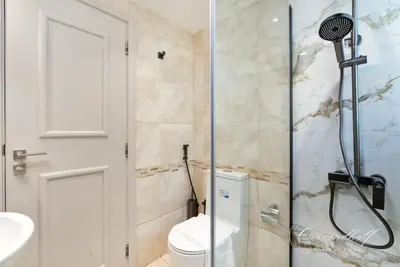 a bathroom with a shower with a toilet and a sink at Cool 1BR with Balcony in Marina, Steps from Metro in Dubai