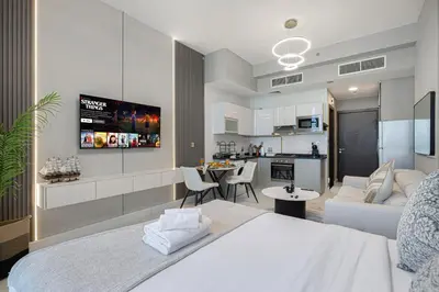 a room with a bed and a living room and a kitchen at Stylish Studio Business Bay Near Dubai Mall in Dubai