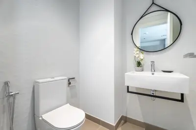 a bathroom with a white toilet and a mirror at GuestReady - 1BR l Stylish 10th-Floor Retreat in Dubai