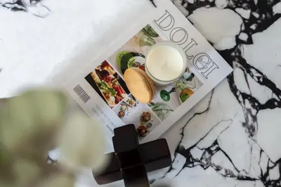 a magazine on a table with a cup of milk at GuestReady - 1BR l Stylish 10th-Floor Retreat in Dubai