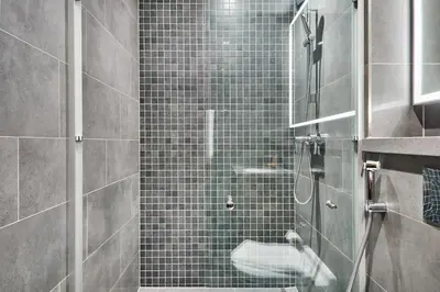 a bathroom with a shower with a glass door at STAY BY LATINEM Luxury 1BR Holiday Home CC 3007 Near Burj Khalifa in Dubai