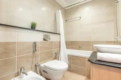 a bathroom with a toilet and a sink and a tub at RH- Marina Living- Chic Ocean Heights 3BR with Panoramic Views in Dubai