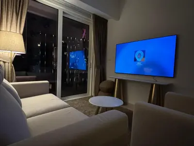 a living room with a couch and a flat screen tv at Mama's Crib Dubai in Sabkhah