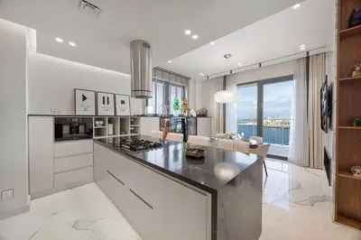a kitchen with a large island with a counter top at Daniels 3BR at La Cote with Full Sea View in Dubai