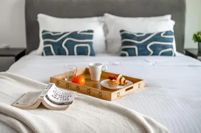 a tray with food and drinks on a bed at 3BR Direct Access to Dubai Mall and Burj Khalifa in Dubai