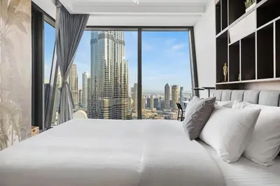 a large white bed in a room with a large window at 3BR Direct Access to Dubai Mall and Burj Khalifa in Dubai