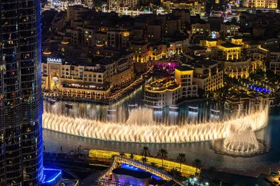 a view of a city at night with a fountain at 3BR Direct Access to Dubai Mall and Burj Khalifa in Dubai