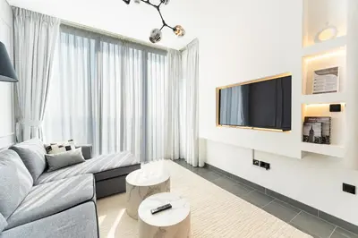 a living room with a couch and a tv at HAVN - 1 bedroom in The Crest, Skyline Views in Dubai