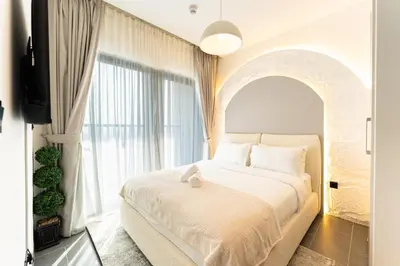 a bedroom with a bed and a large window at HAVN - 1 bedroom in The Crest, Skyline Views in Dubai