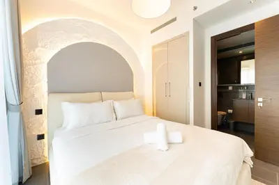 a bedroom with a white bed with a candle on it at HAVN - 1 bedroom in The Crest, Skyline Views in Dubai