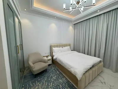 a bedroom with a bed and a chair and a chandelier at Vincitore Benessere - Arjan by Golden Casa in Dubai