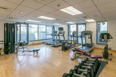 a gym with several treadmills and elliptical machines at 2BR 29Blvd Balcony Fountain View in Dubai