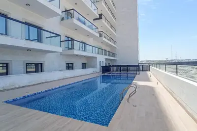 a swimming pool in front of a building at StayShort - Stunning 2BR Apartment in Jebel Ali Village in Dubai