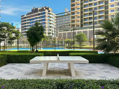 a white bench in a park with tall buildings at Modern 1BR Near World Trade Center Metro in Dubai