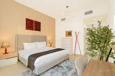 a bedroom with a large bed and a table at Escape24 Chic 1BR in Al Furjan near Metro in Dubai