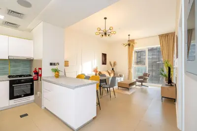 a kitchen and living room with a table and chairs at Escape24 Chic 1BR in Al Furjan near Metro in Dubai
