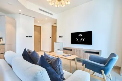 a living room with a couch and a tv at STAY BY LATINEM Luxury 2BR Holiday Home W2013 near Downtown in Dubai