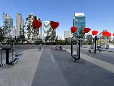 a park with benches and tables in front of a city at Vogue Downtown Mag 318 near Burj Khalifa and Dubai Mall, Studio Apartment with Balcony and City View, Access to all Amenities in Dubai