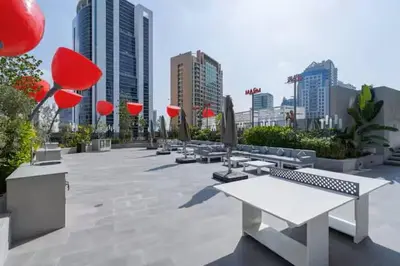 a park with benches and umbrellas in a city at Vogue Downtown Mag 318 near Burj Khalifa and Dubai Mall, Studio Apartment with Balcony and City View, Access to all Amenities in Dubai