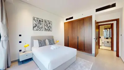 a bedroom with a white bed and a wooden door at Vacationer I Premium 2 Bedroom Apartment I Close to DIFC & WTC I Central Location in Dubai