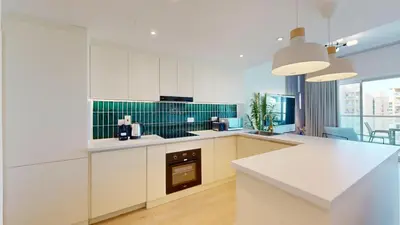 a kitchen with white cabinets and green tiles at Vacationer l Upgraded Chic 2 Bed l Pool View l Free Pool, Gym Access in Dubai