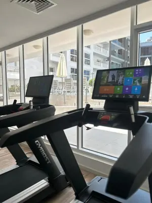 a gym with a treadmill with a computer on it at Modern Apartment in JVC in Dubai