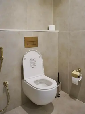 a bathroom with a toilet with the lid up at Modern Apartment in JVC in Dubai