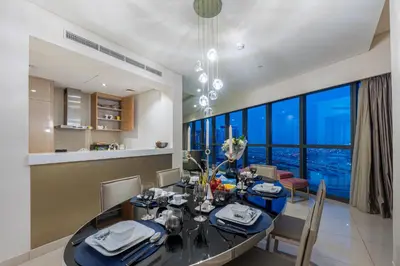 a dining room with a table and a large window at Venetian - High Floor 2BR Residence with Incredible Burj View in Dubai