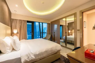 a bedroom with a large bed and a large mirror at Venetian - High Floor 2BR Residence with Incredible Burj View in Dubai