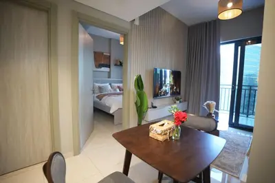 a living room with a table and a bedroom at Joyful Journeys Downtown And Burj View Residence Business Bay One-Bedroom Apartment in Dubai