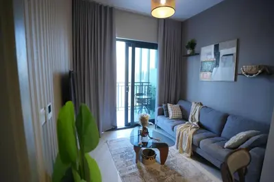 a living room with a blue couch and a table at Joyful Journeys Downtown And Burj View Residence Business Bay One-Bedroom Apartment in Dubai