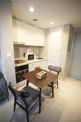 a kitchen with a wooden table and two chairs and a table at Joyful Journeys Downtown And Burj View Residence Business Bay One-Bedroom Apartment in Dubai
