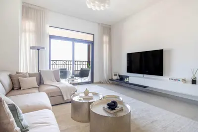 a living room with a couch and a tv at Frank Porter - Rahaal 2 in Dubai