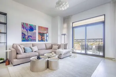 a living room with a couch and a large window at Frank Porter - Rahaal 2 in Dubai