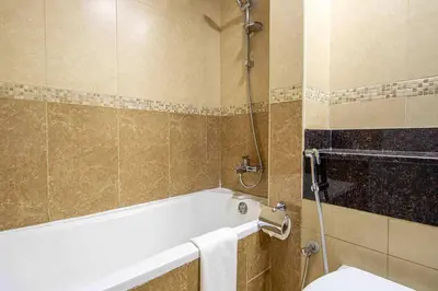 a bathroom with a bath tub and a toilet at Frank Porter - Goldcrest Views 2 in Dubai