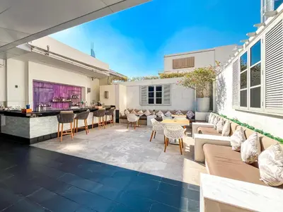 an outdoor patio with furniture and a bar at 1BR Apt Kempinski Central Avenue Downtown Dubai in Dubai