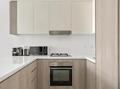 a white kitchen with a microwave and a stove at Luxury 1BR in LIV Marina with Canal Views in Dubai