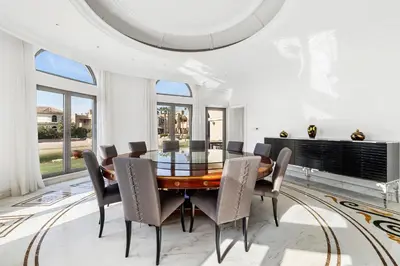 a dining room with a glass table and chairs at Luxury 5BR plus Maid Private Villa with Direct Beach Access in Dubai