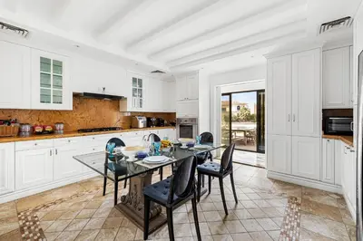 a white kitchen with a table and chairs in it at Luxury 5BR plus Maid Private Villa with Direct Beach Access in Dubai