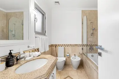 a bathroom with a sink and a toilet and a mirror at Luxury 5BR plus Maid Private Villa with Direct Beach Access in Dubai