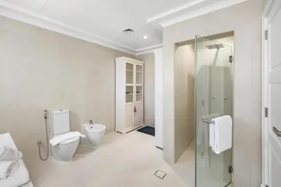 a bathroom with a toilet and a glass shower at Luxury 5BR plus Maid Private Villa with Direct Beach Access in Dubai