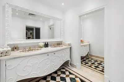 a white bathroom with two sinks and a mirror at Luxury 5BR plus Maid Private Villa with Direct Beach Access in Dubai