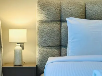 a bedroom with a bed with a white pillow and a lamp at Venduras - Luxe Studio, City Views , Sterling by Omniyat in Dubai