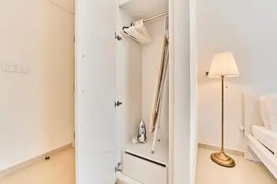 a white bedroom with a bed and a lamp at Stunning 2BR Skyline Stay With Full Burj Khalifa View in Dubai