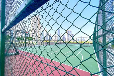a batting cage with a tennis court in a city at Stunning 2BR Skyline Stay With Full Burj Khalifa View in Dubai