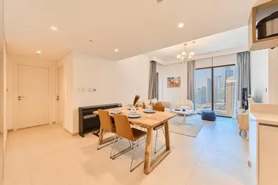a dining room and living room with a table and chairs at Stunning 2BR Skyline Stay With Full Burj Khalifa View in Dubai