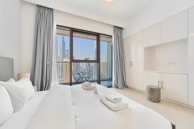 a bedroom with two white beds and a large window at Stunning 2BR Skyline Stay With Full Burj Khalifa View in Dubai